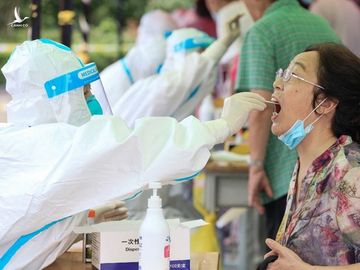 Nhân viên y tế lấy mẫu xét nghiệm Covid-19 cho một phụ nữ ở thành phố Nam Kinh, tỉnh Giang Tô, Trung Quốc hôm 29/7. Ảnh: AFP.