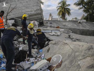 Lính cứu hỏa tìm kiếm người còn sống sót bên trong tòa nhà bị tàn phá ở Les Cayes, Haiti, hôm 15/8. Ảnh: AP.