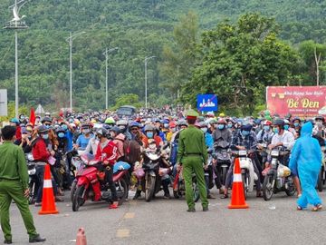 Người dân đi xe máy về quê ở chân đèo Hải Vân, Thừa Thiên Huế. Ảnh: Vạn An