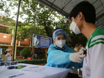 [Nhân viên y tế khám sàng lọc, kiểm tra sức khỏe học sinh trước khi tiêm vaccine hôm 27/10 ở huyện Củ Chi. Ảnh: Đình Văn