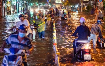 Người dân TP.HCM bì bõm lội nước về nhà trong mưa lớn