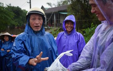 Dân vùng lũ tặng quà cho đoàn từ thiện