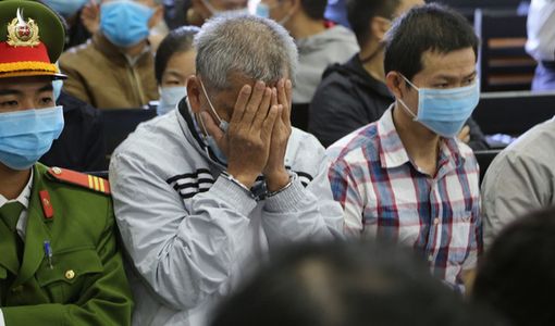 Đại gia xăng dầu Trịnh Sướng lấy tay che mặt trước ống kính của phóng viên tại tòa