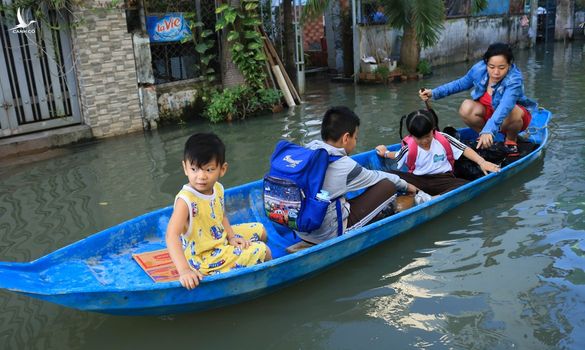 Người dân TP.HCM chèo xuồng đưa con đi học vì đường ngập mãi không hết